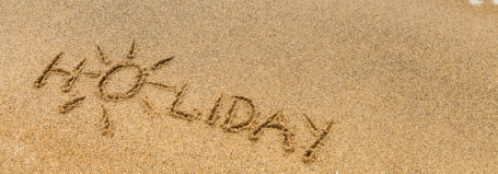 Mot "Holiday" écrit sur le sable