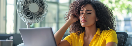 Illustration d'une femme avec un ventilateur au bureau 