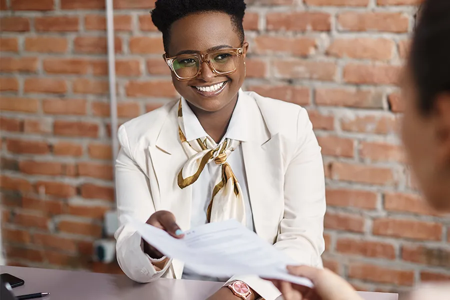 Recruteuse souriante finalisant un recrutement efficace grâce au logiciel Kelio ATS.