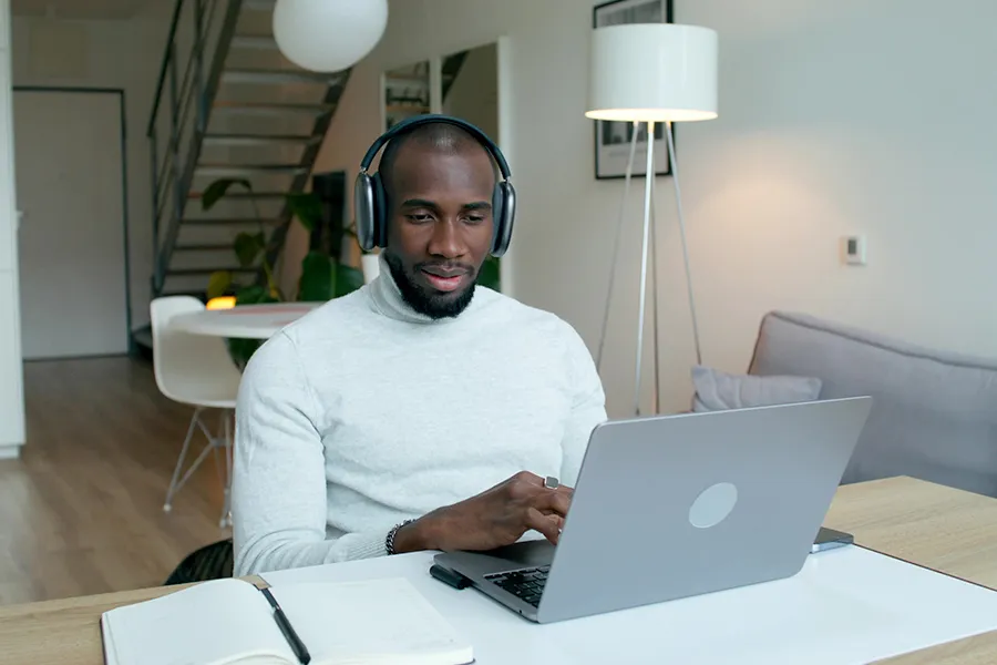 Un homme avec un casque travaillant devant son ordinateur à son domicile